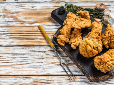 Crispy chicken drumstick, leg, wing and breast strips. White Wooden background. Top view. Copy space.