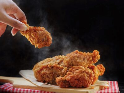 woman-hand-taking-the-fried-chicken-wings-by-hands-2024-12-04-21-24-06-utc